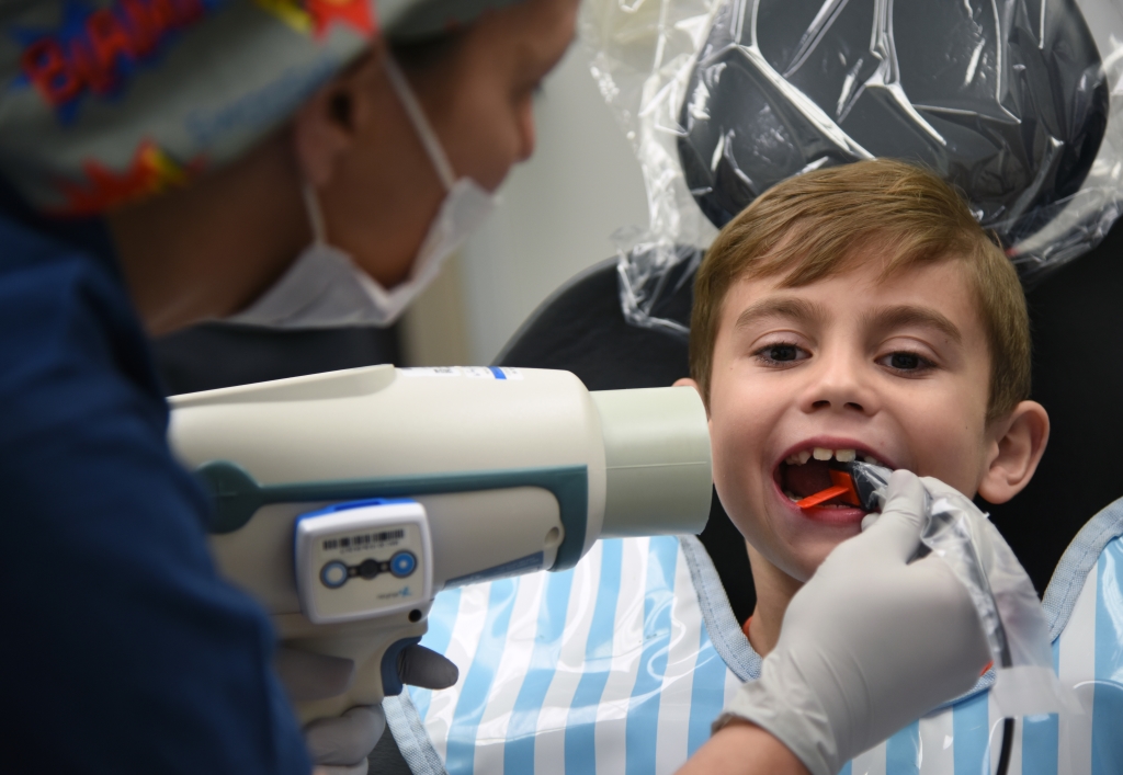 kid at dentist getting x-ray to find cavities