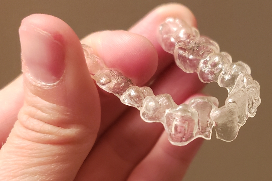 Teen holding a cracked Invisalign tray