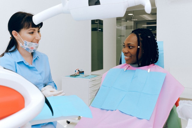 Woman talking to dentist about warning signs and treatment for gum disease